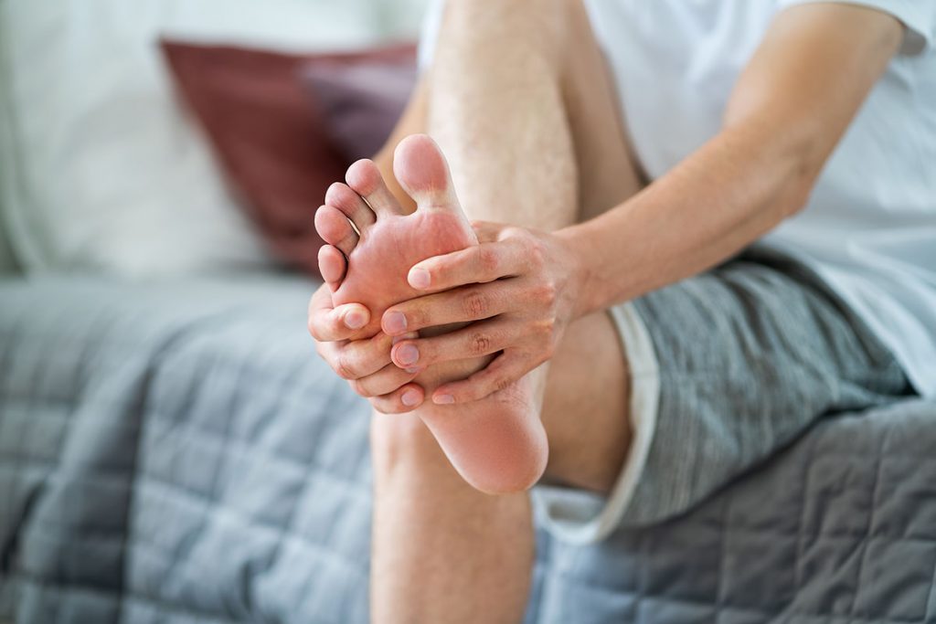 Foot pain, man suffering from feet ache